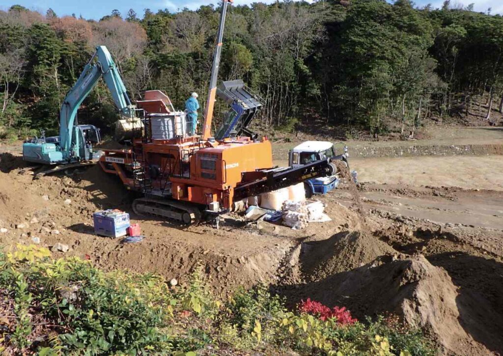 自走式土地改良機へ土を入れている状況